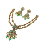 Gold necklace with green gemstones on a white background