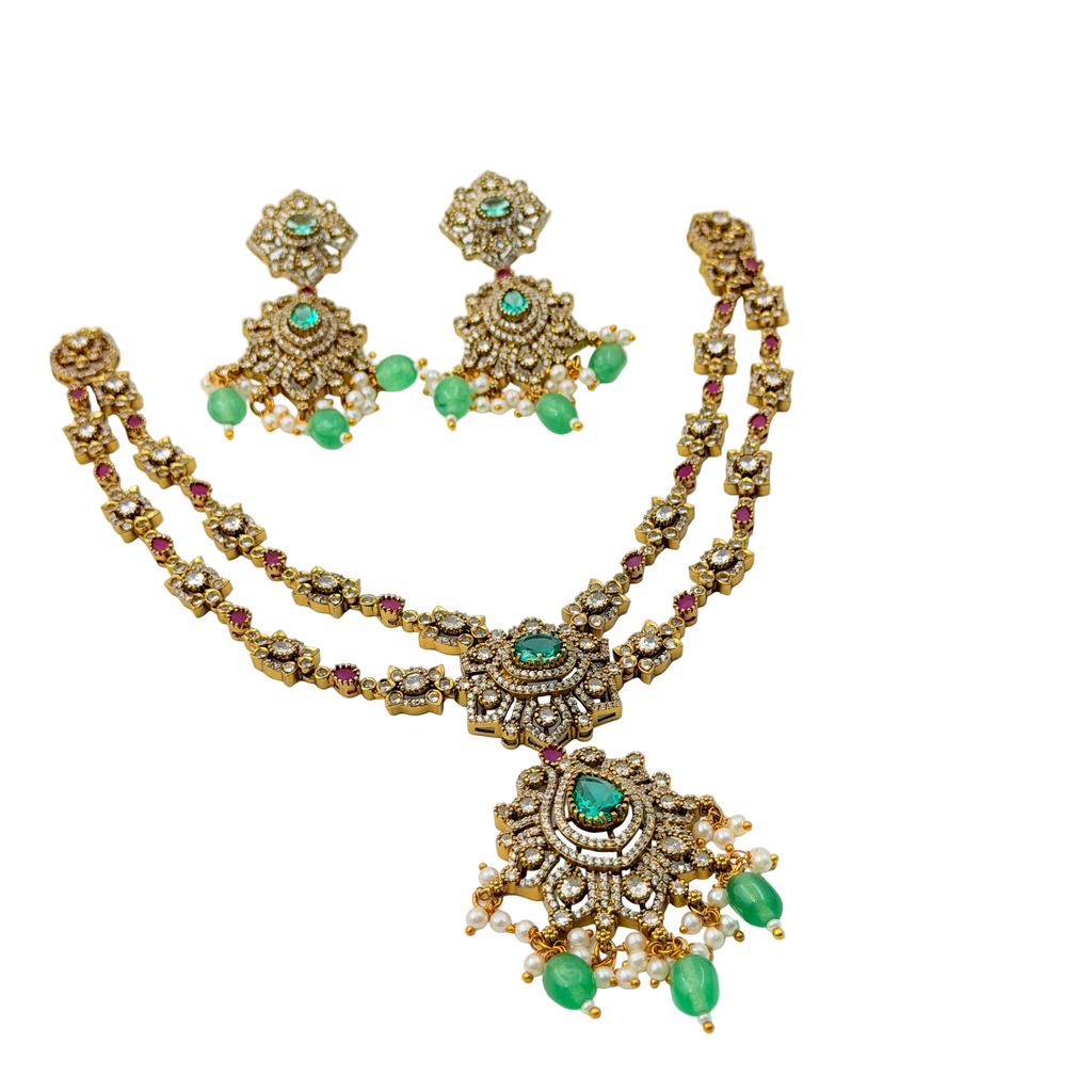 Gold necklace with emeralds and rubies on a white background