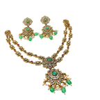 Gold necklace with emeralds and rubies on a white background