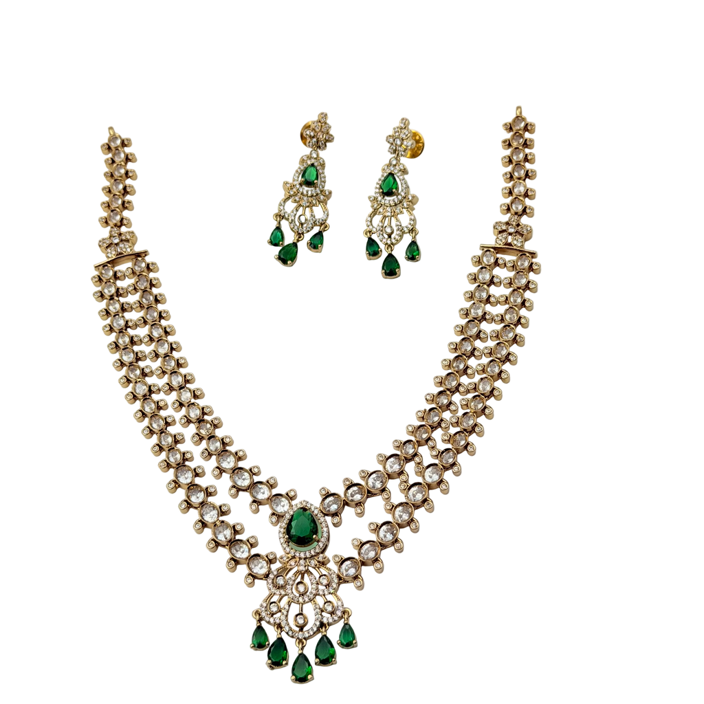Jewelry set with necklace and earrings featuring green gemstones on a white background
