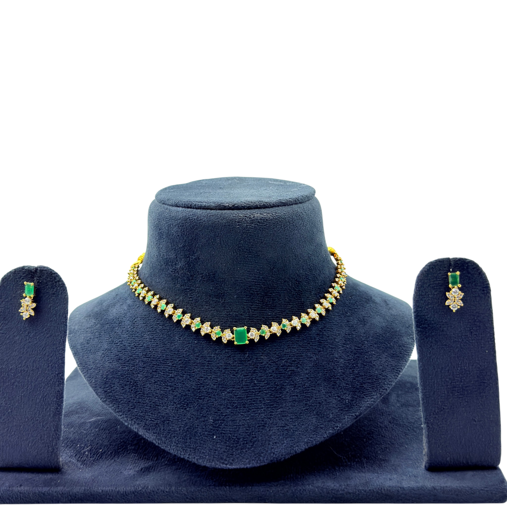 Jewelry set with necklace and earrings on a blue velvet stand against a white background