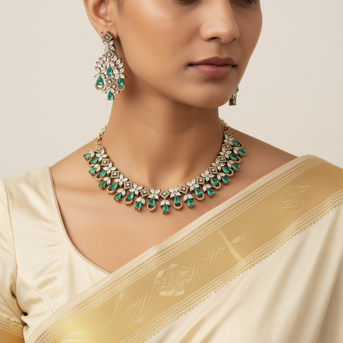 Woman wearing a gold and green necklace with matching earrings, dressed in a beige saree.