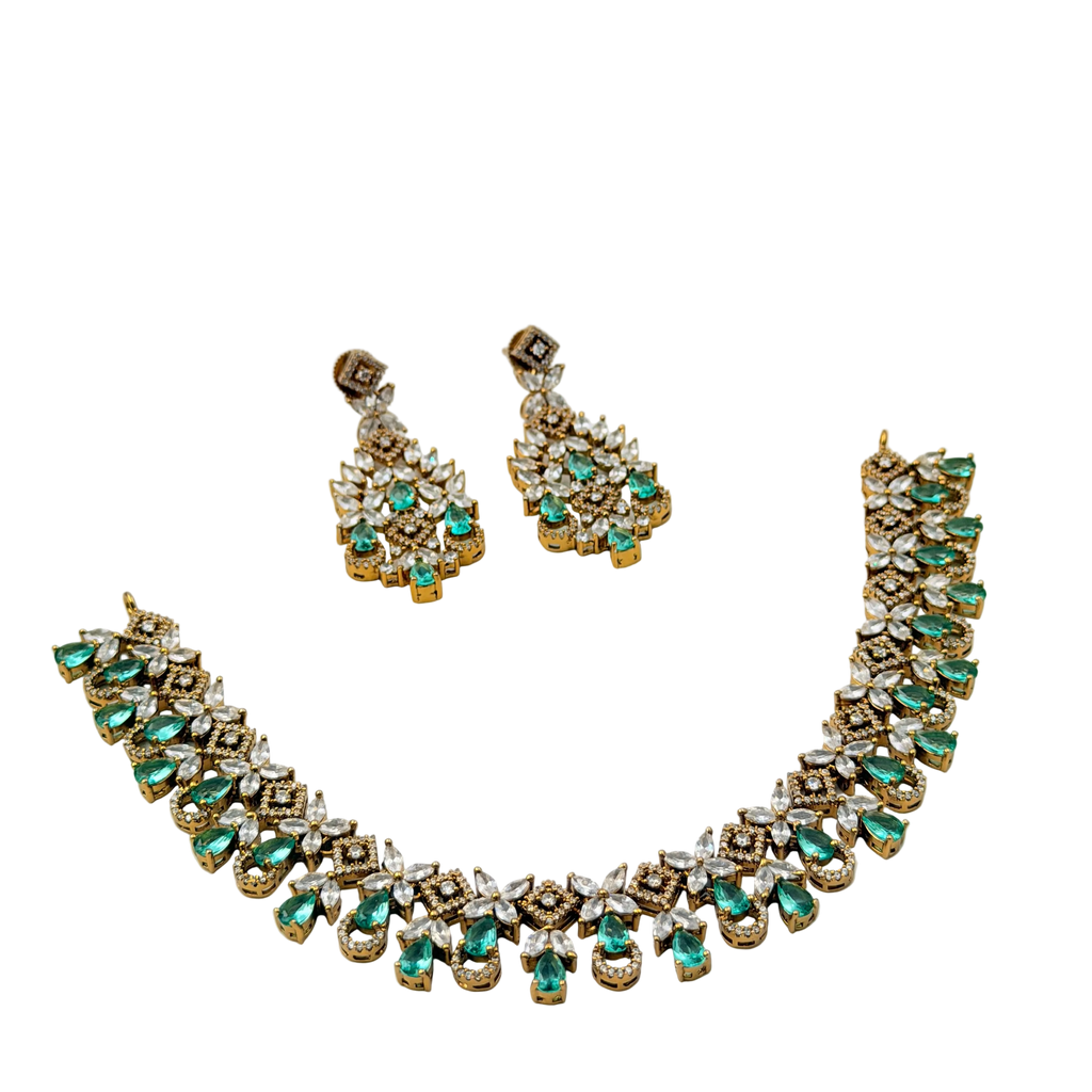 Jewelry set with necklace and earrings featuring green gemstones on a white background