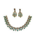 Jewelry set with necklace and earrings featuring green gemstones on a white background