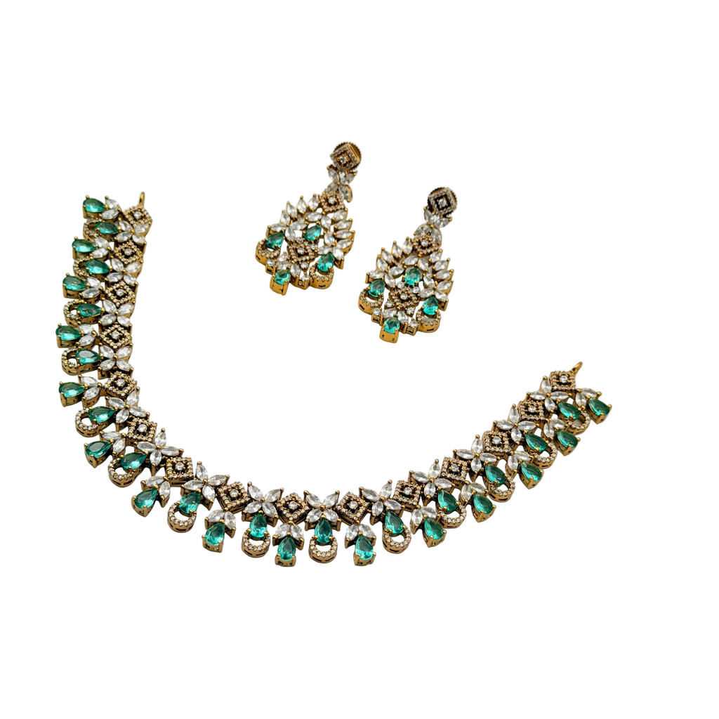 Jewelry set with necklace and earrings featuring green gemstones on a white background