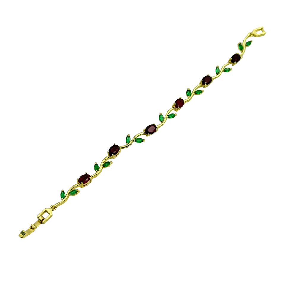 Gold bracelet with green and red gemstones on a white background