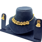 Gold necklace and earrings set on a blue velvet stand