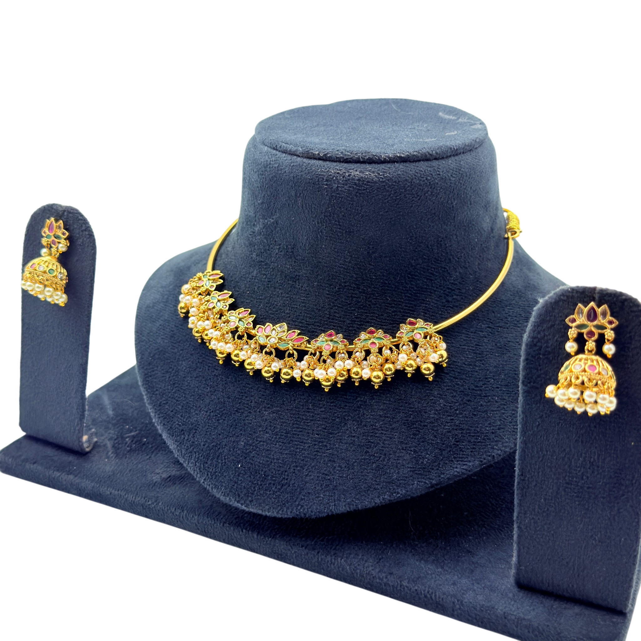 Gold necklace and earrings set on a blue velvet stand
