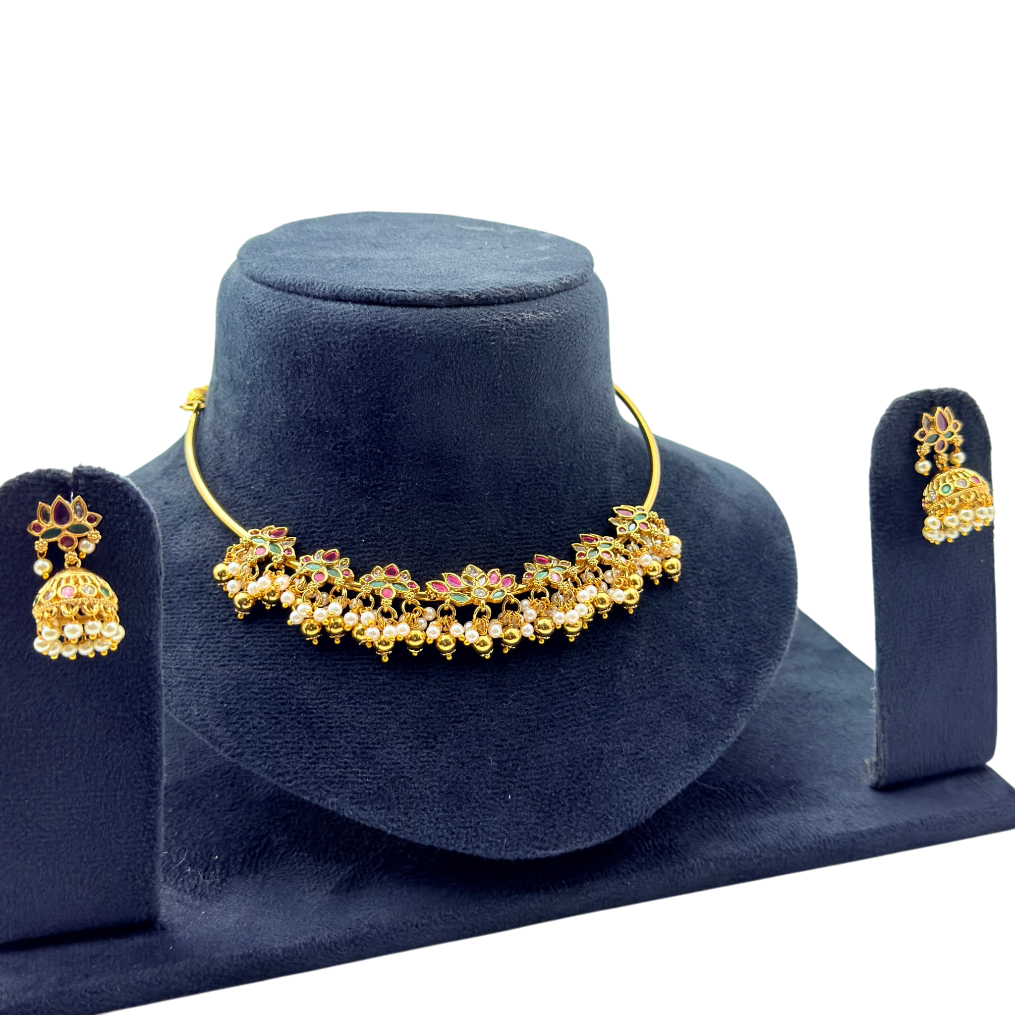Gold necklace and earrings set on a blue velvet stand