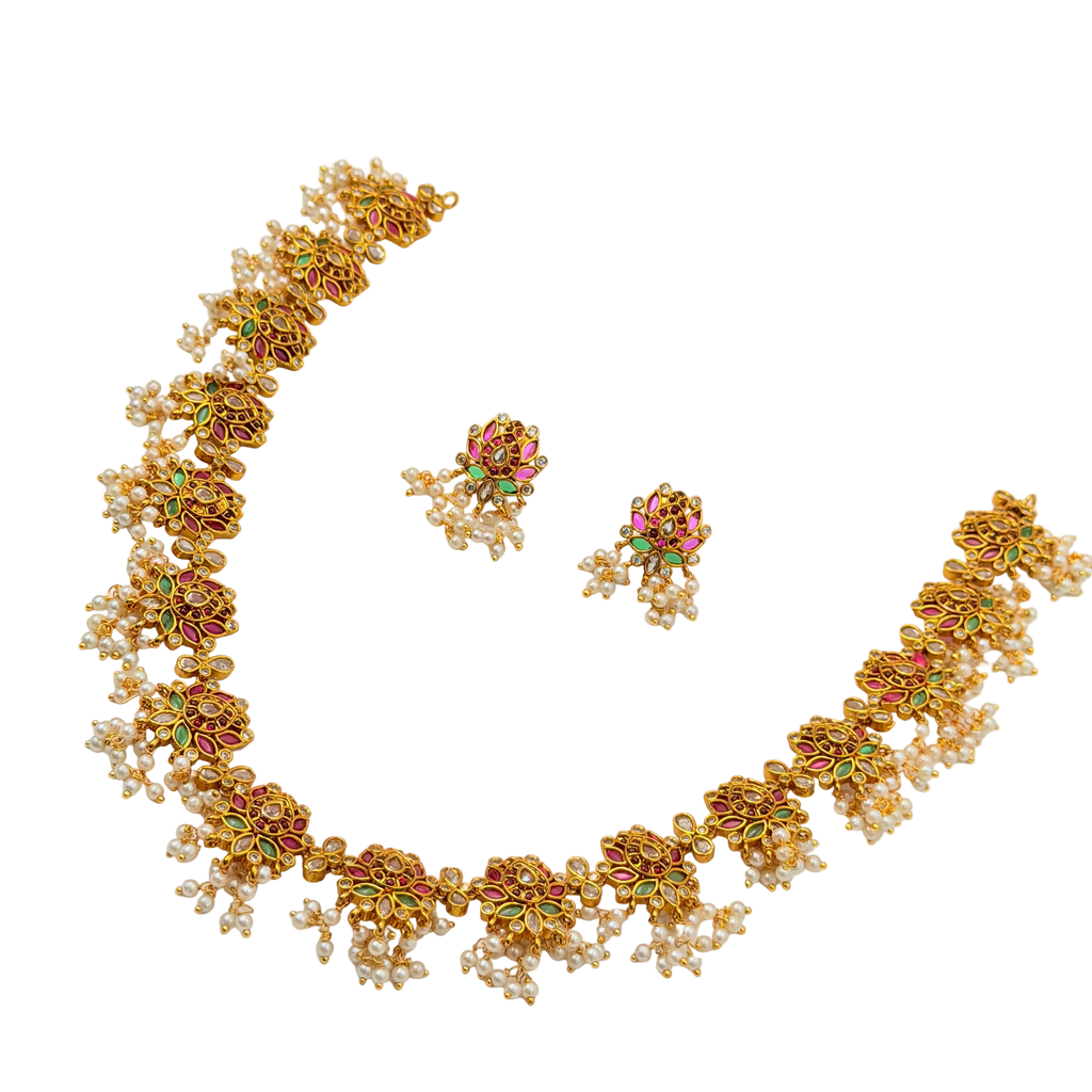 Gold necklace and earrings set on a white background