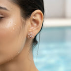 Rose gold-tone floral pave stud earring with central crystal, close-up on-ear shot