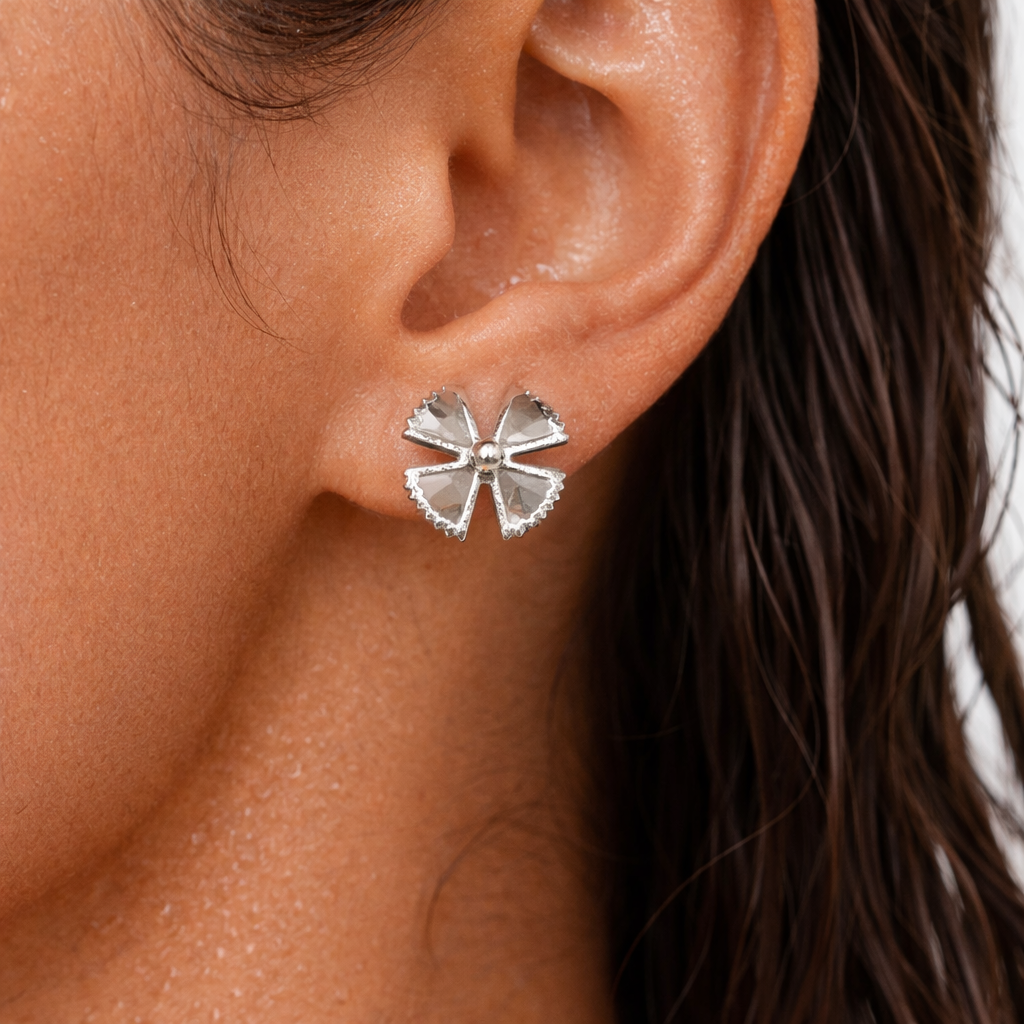 Silver bow-shaped earrings worn by a person with dark hair.