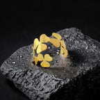 Gold leaf-shaped ring on a dark stone surface