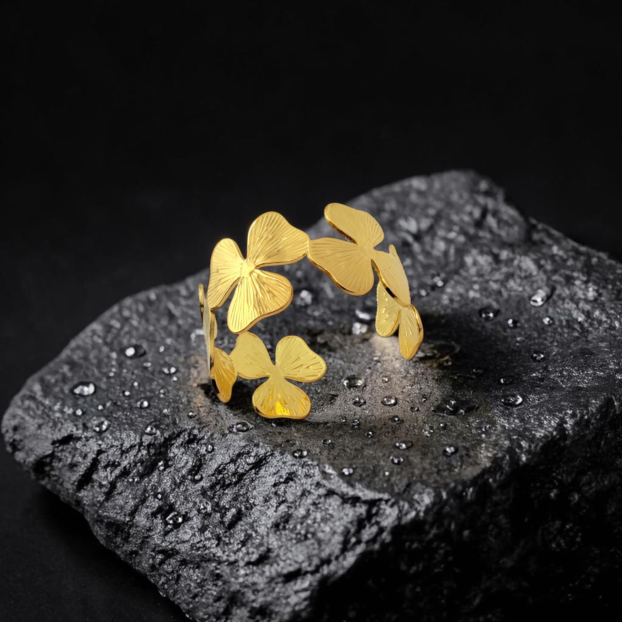 Gold leaf-shaped ring on a dark stone surface