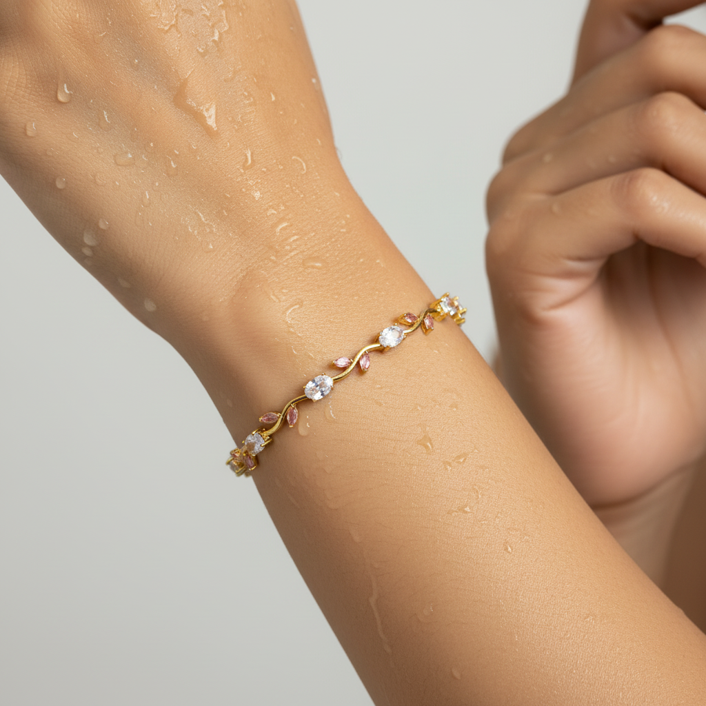 Delicate bracelet with pink and clear stones on a wrist against a neutral background