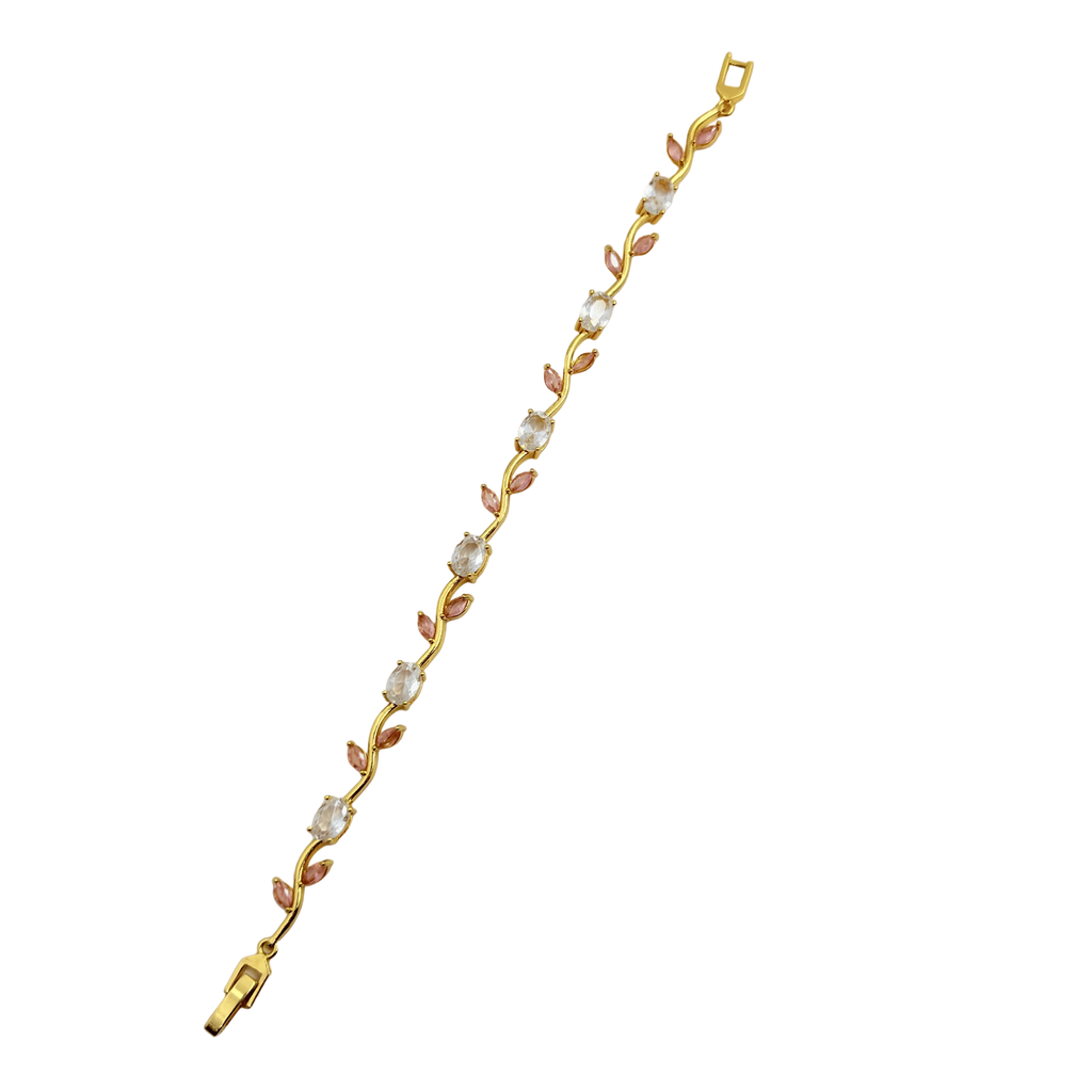 Gold bracelet with pink and white stones on a black background