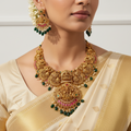 Woman wearing a gold necklace and earrings with a white background