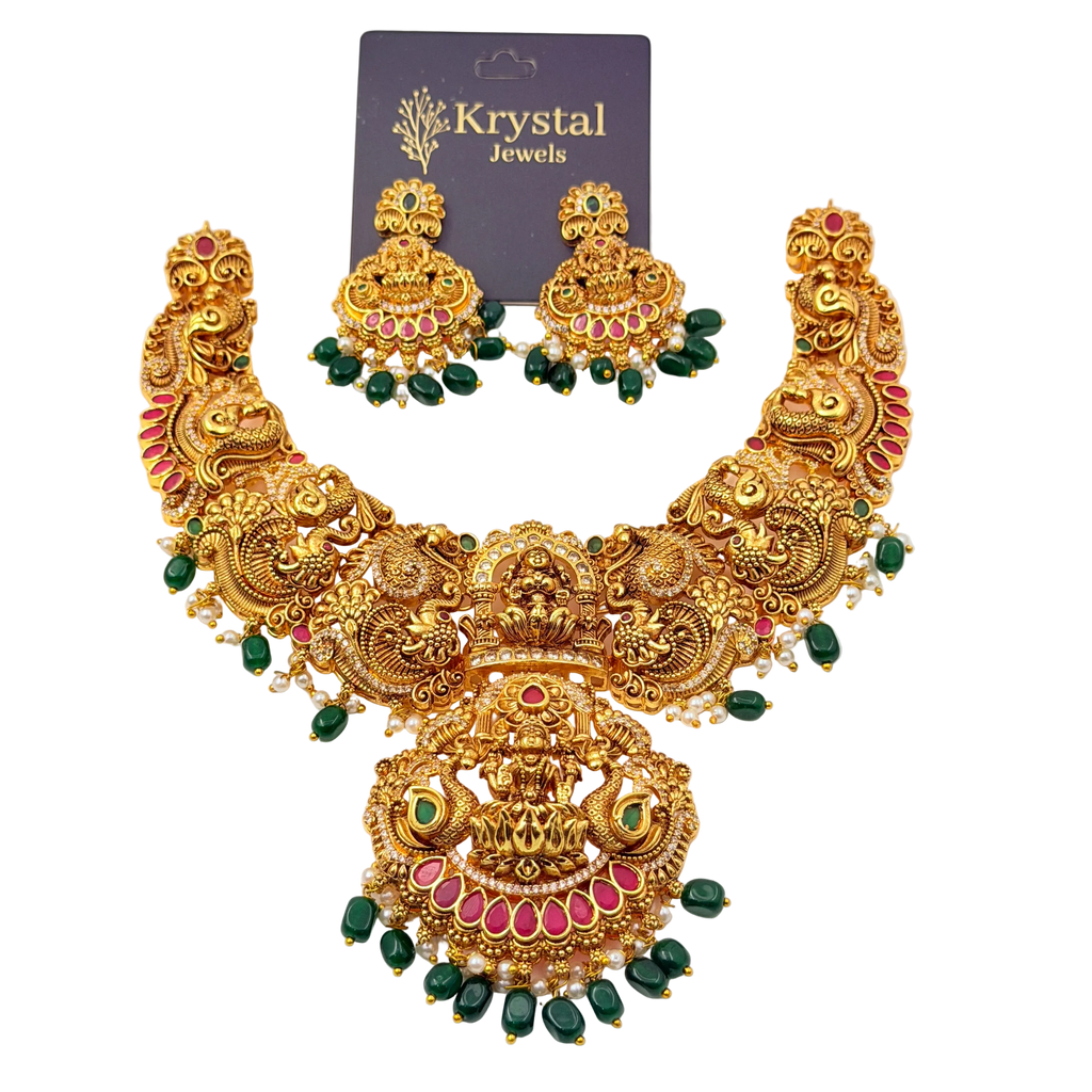 Gold necklace with green and red stones on a white background, branded as Krystal Jewels.