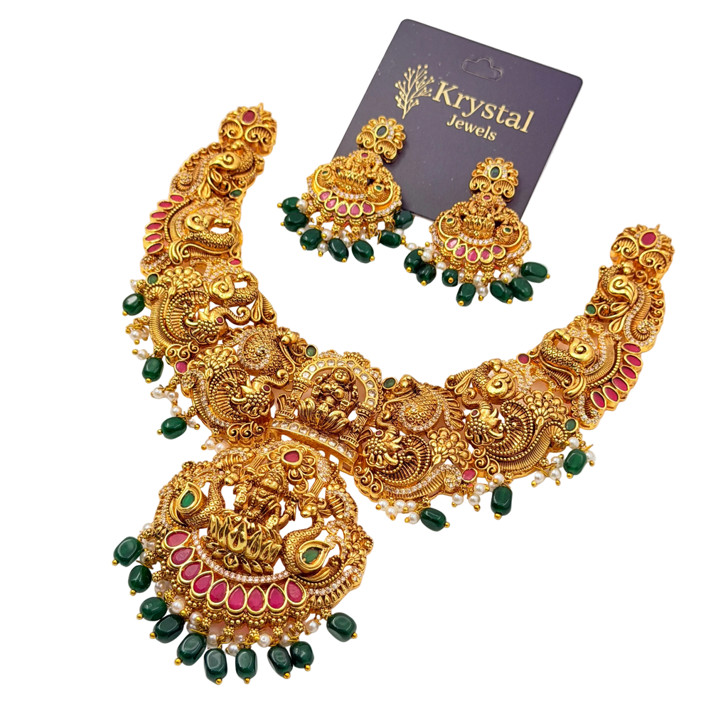 Ornate gold necklace with green and red stones on a transparent background, branded 'Krystal Jewels'.