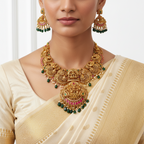 Woman wearing a gold necklace and earrings with a white saree