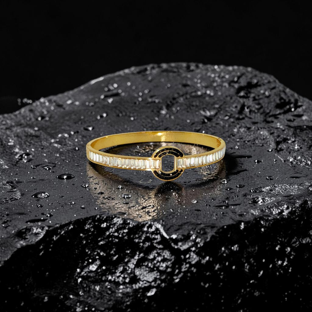 Gold bracelet with black center on a dark textured surface