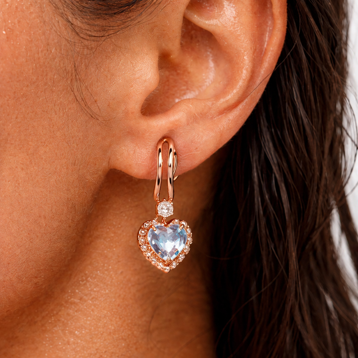 Close-up of an ear wearing a rose gold heart-shaped earring 