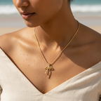 Gold-tone bowknot pendant necklace with clear crystal accent, worn on model's neckline showing chain length