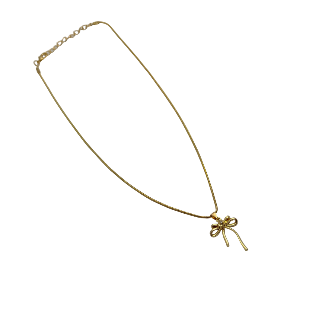 Gold-tone bowknot ribbon pendant with clear crystal center, flat-lay view of chain and clasp