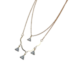 Gold-tone double-layered necklace with wavy bar and four trillion-cut crystal charms, flat lay on black background