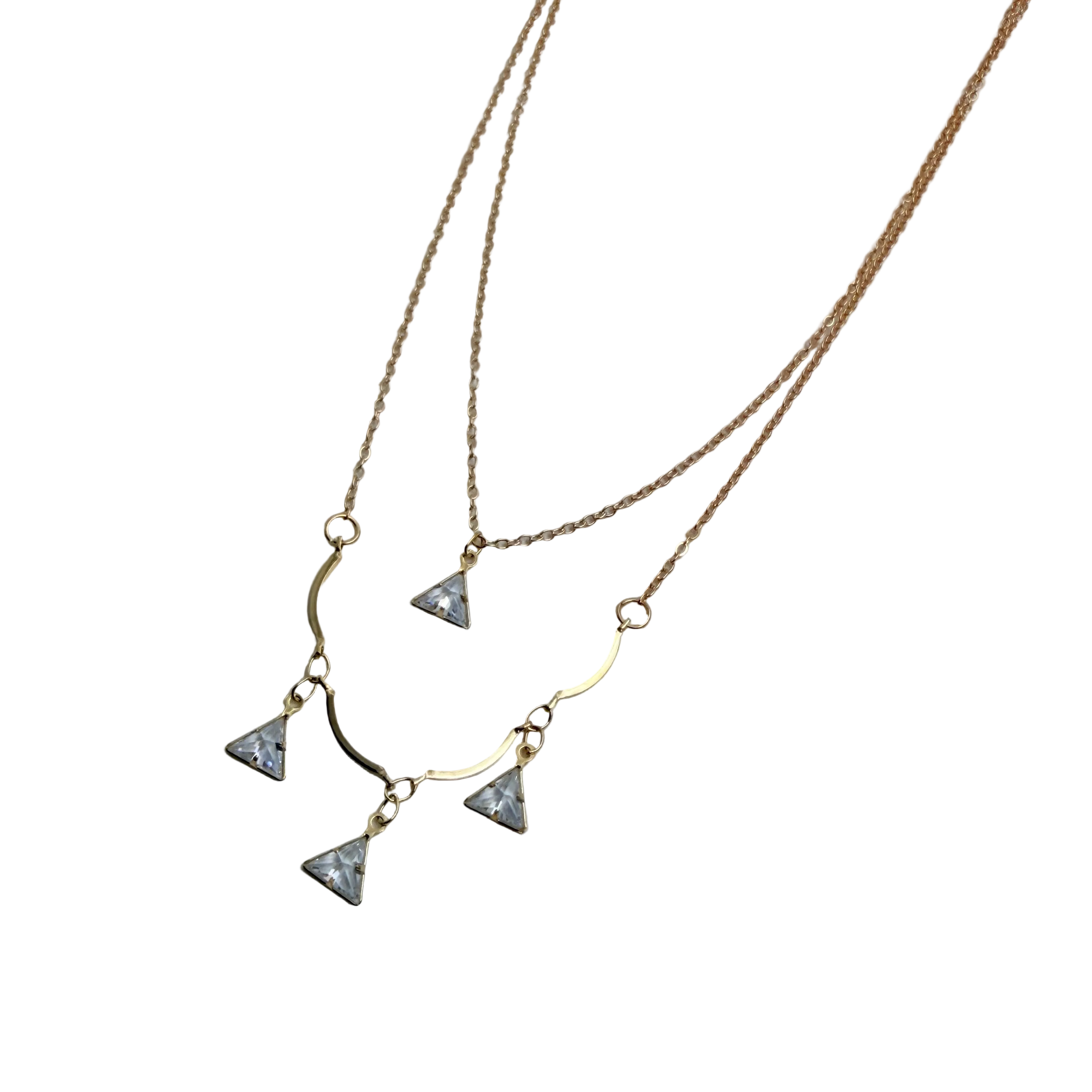 Gold-tone double-layered necklace with wavy bar and four trillion-cut crystal charms, flat lay on black background
