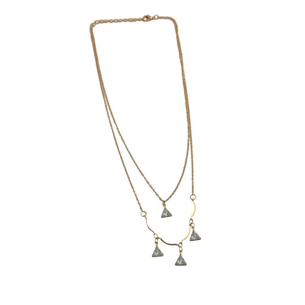 Gold-tone double-layered necklace with wavy bar and four trillion-cut crystal charms, flat lay on black background
