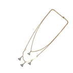 Gold-tone double-layered necklace with wavy bar and four trillion-cut crystal charms, angled flat lay on black background