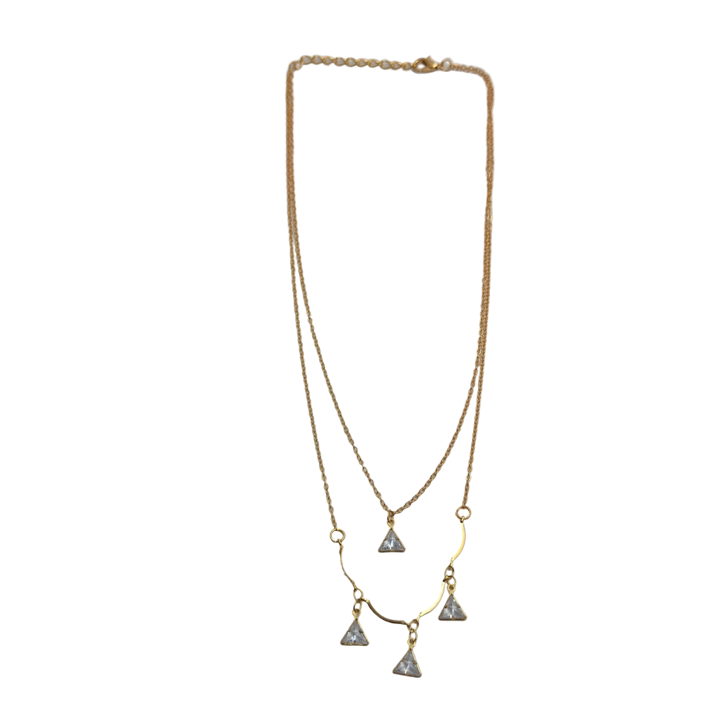 Gold-tone double-layered necklace with wavy bar and four trillion-cut crystal charms, flat lay on white background