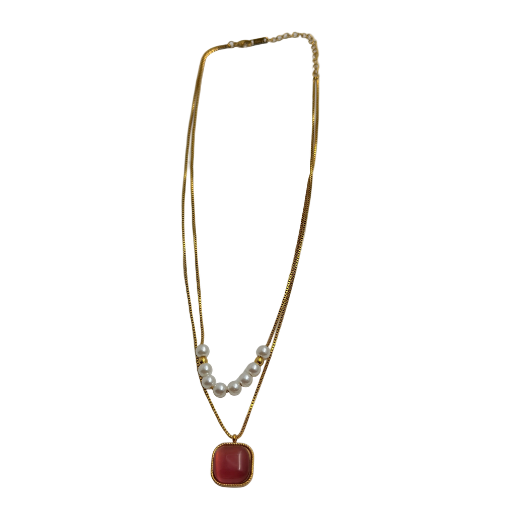Gold-tone layered necklace with pearls and carnelian pendant, full flat-lay view on white background
