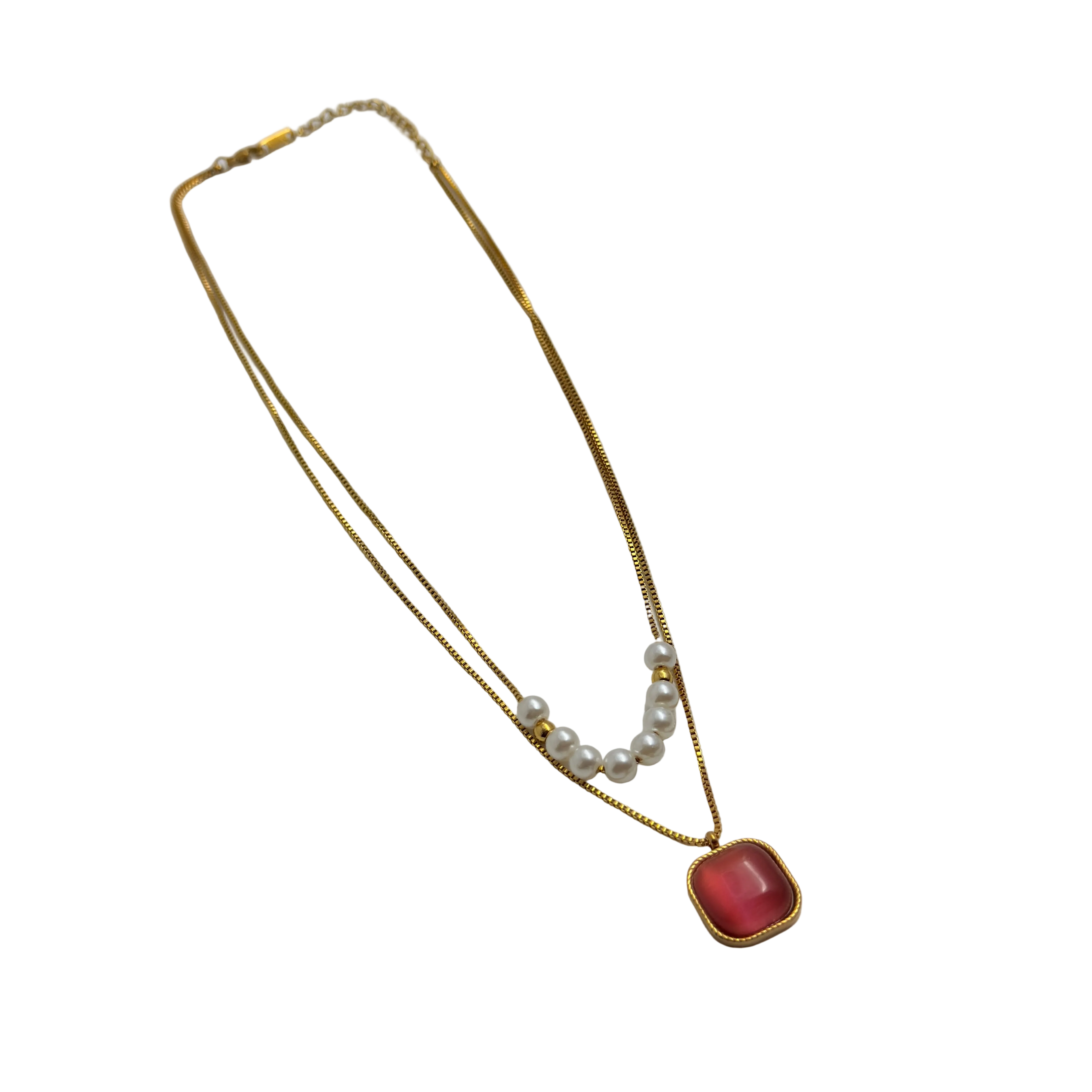 Gold-tone layered necklace with pearls and carnelian pendant, full flat-lay view on black background