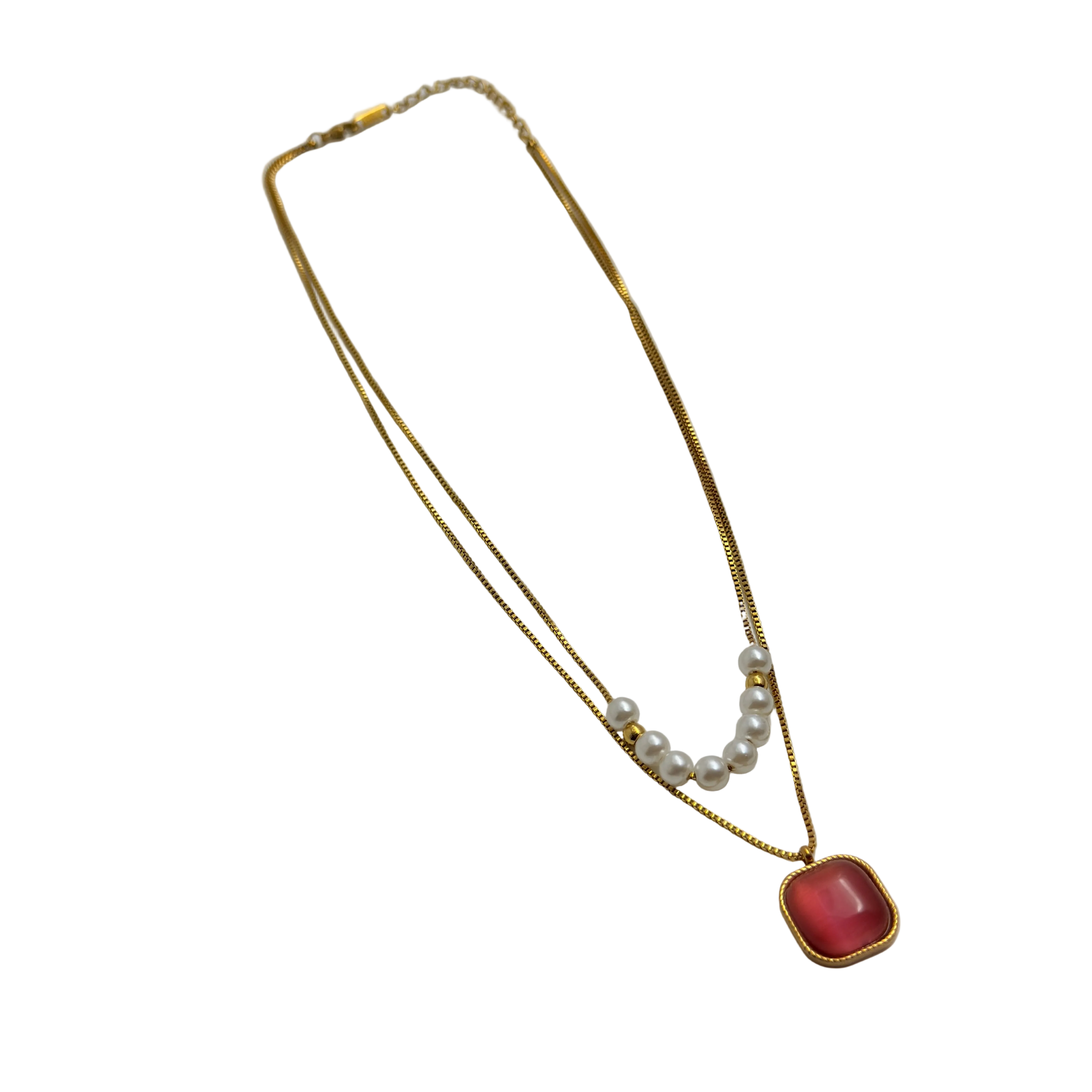 Gold-tone layered necklace with pearls and carnelian pendant, full flat-lay view on black background