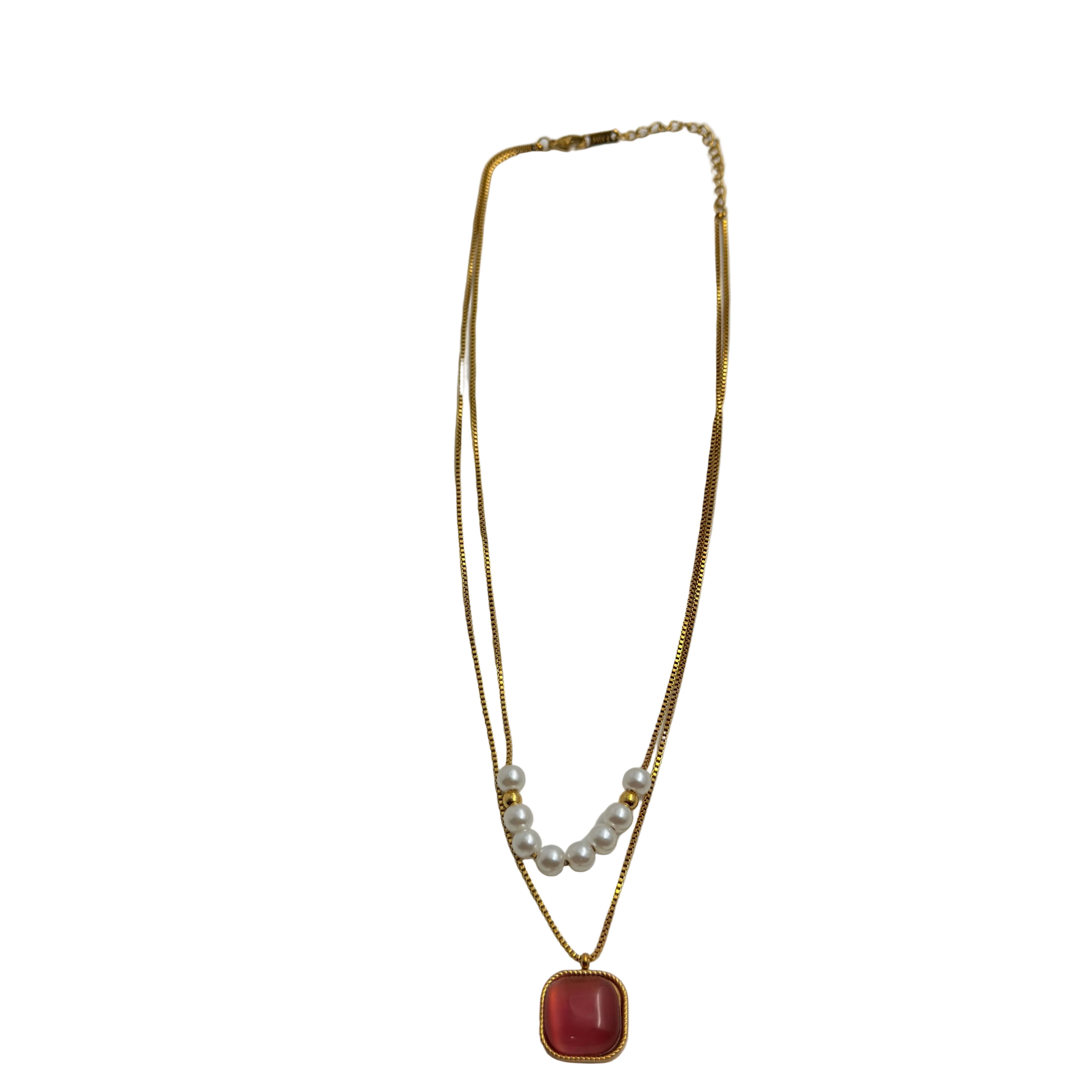 Gold-tone necklace pendant close-up showing cushion-cut carnelian cabochon and pearl accents
