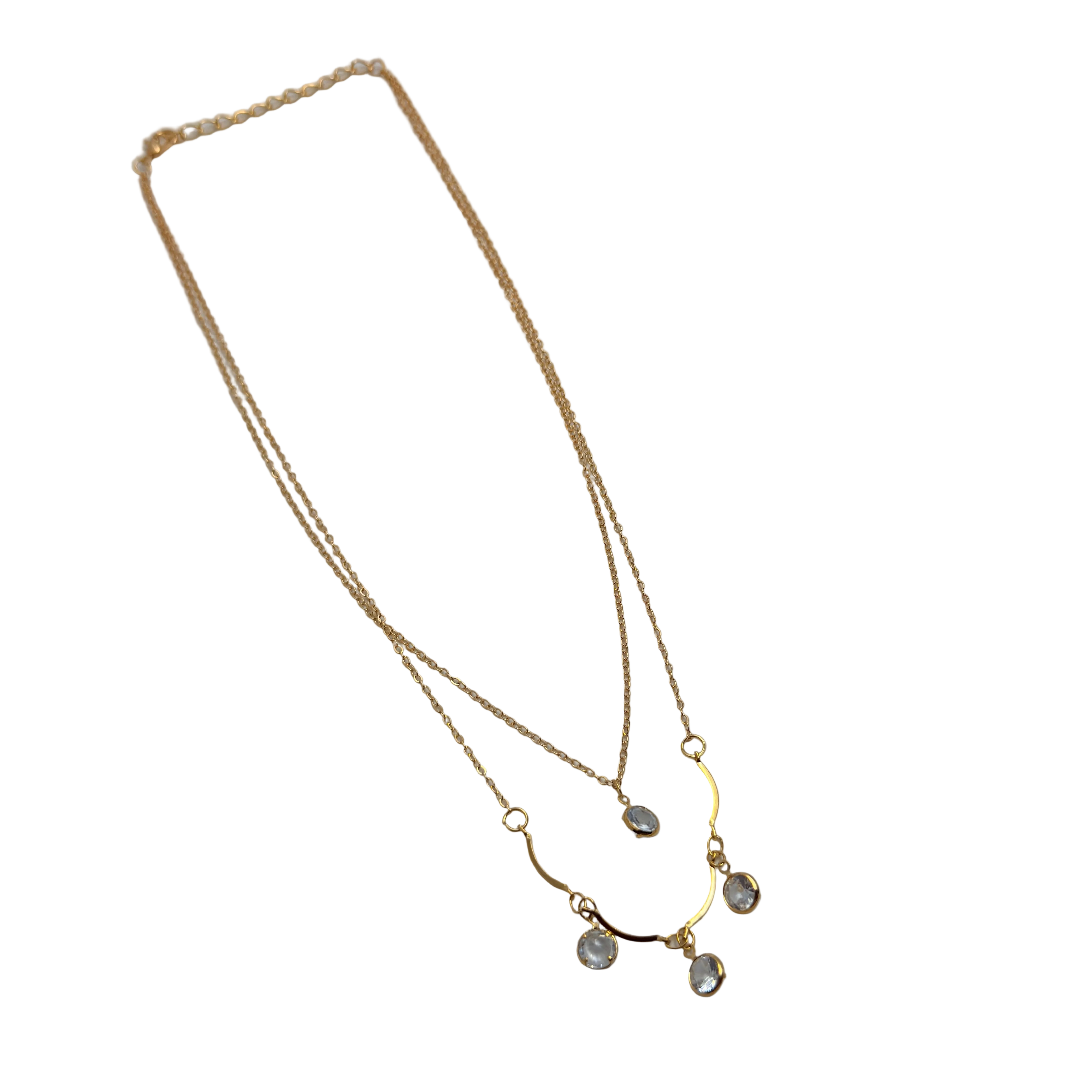 Gold-tone double-layer necklace with clear crystal charms, flat lay showing full chain length