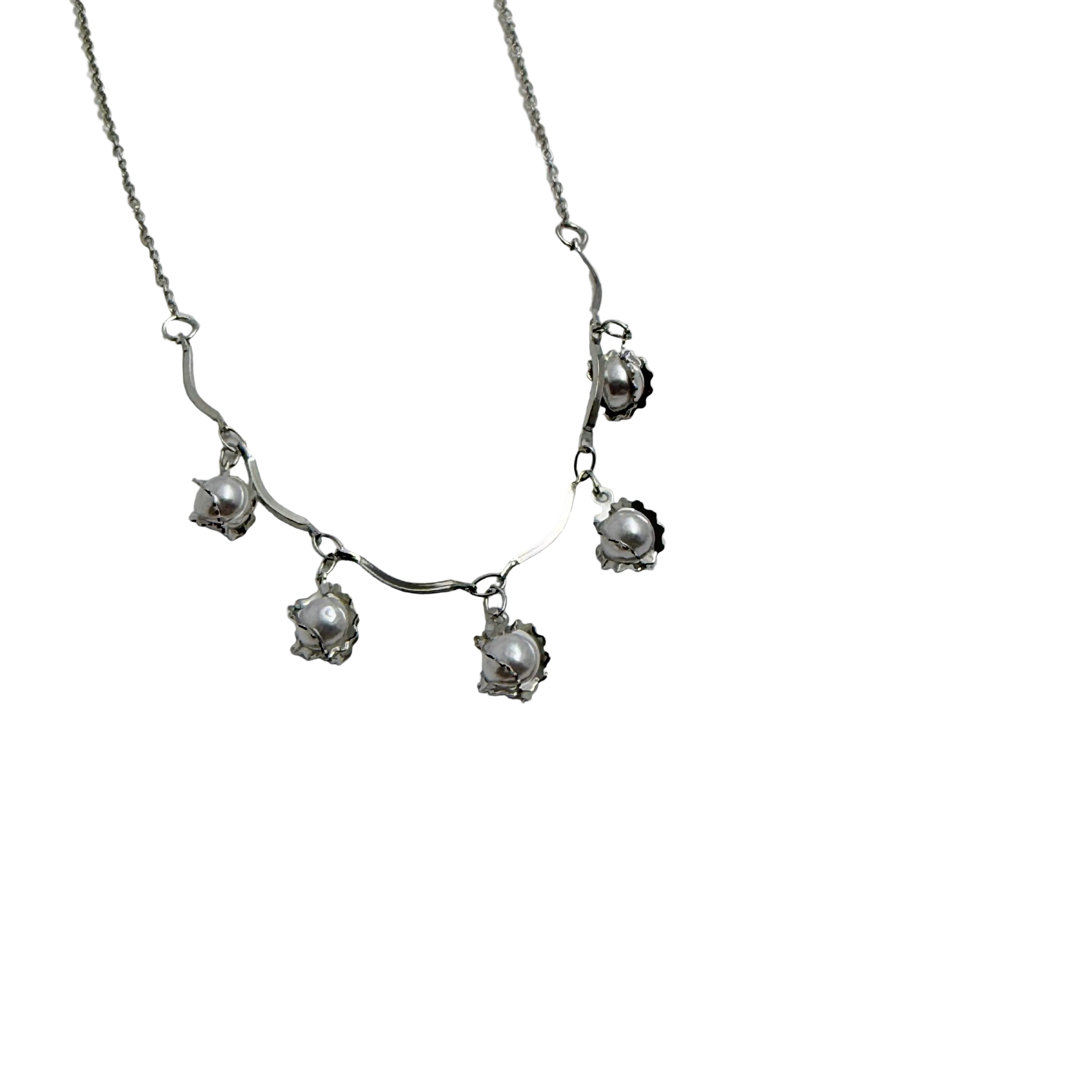 Silver-tone pearl charm necklace with wavy collar bar, worn on neck at the beach