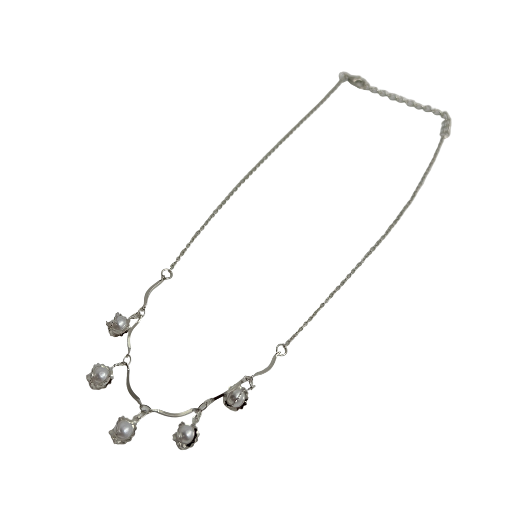 Silver-tone pearl flower bud charm necklace with cable chain, angled flat-lay view