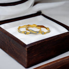 Two-tone gold bangle set with wavy rhodium accents and CZ eye motif, worn on wrist