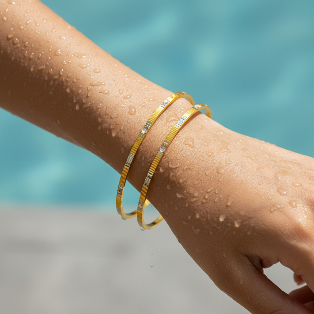 Gold bangle set with sparkling stone accents, two slim ribbed bangles worn on wrist