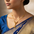 Gold-plated beaded tassel necklace with textured gold bead drops, worn on model with blue saree