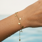 Gold-tone butterfly charm chain bracelet, worn on wrist close-up