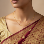 Gold beaded twisted-link chain necklace worn on model with saree, on-neck view