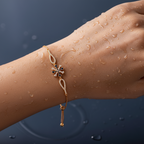 Rose gold adjustable chain bracelet with floral CZ motif and blue accents, worn on wrist