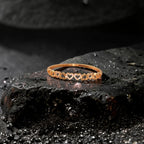 Rose gold heart bracelet with crystal-pave open-heart motifs, flat-lay on dark stone