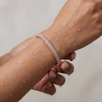 Rose gold bangle bracelet with double row of crystals, worn on a wet wrist