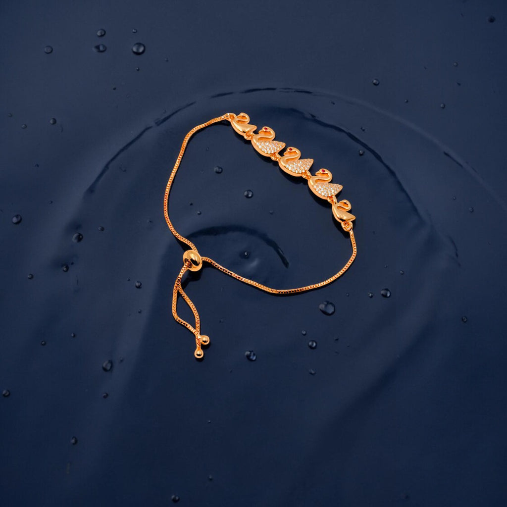 Rose gold swan bracelet with crystal-studded swan motifs and adjustable slider, worn on wrist by water