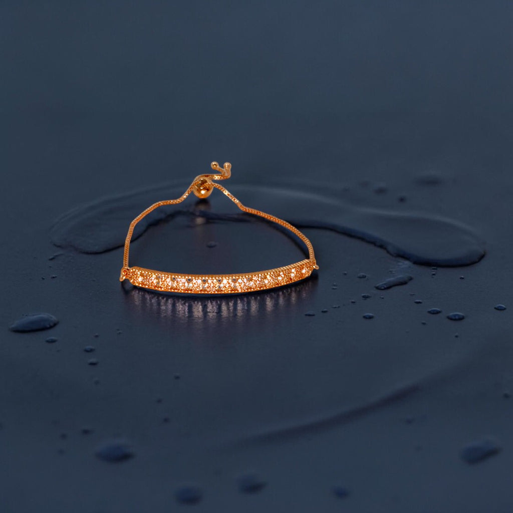 Rose gold crystal-bar adjustable bracelet with box chain and pearl accent, flat-lay close-up
